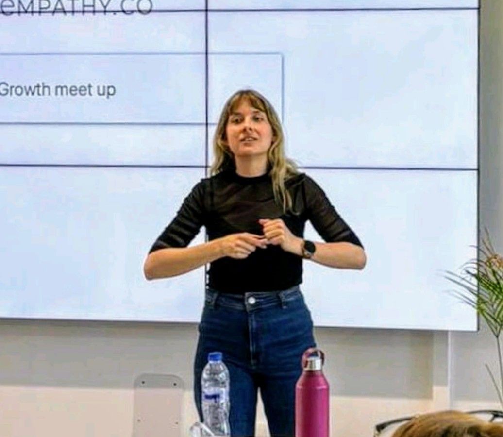 Erica impartiendo una formación en ventas ante un equipo en una sala de reuniones